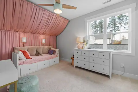 Elegant children's bedroom with pink decor and modern furniture.