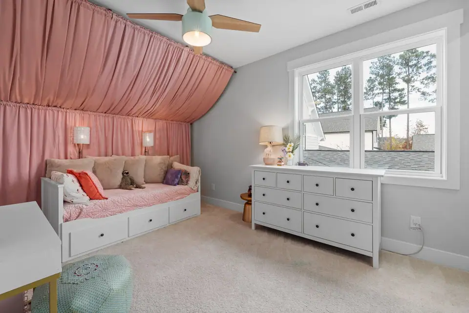 A child bedroom with a wide white eight-drawer dresser under the window